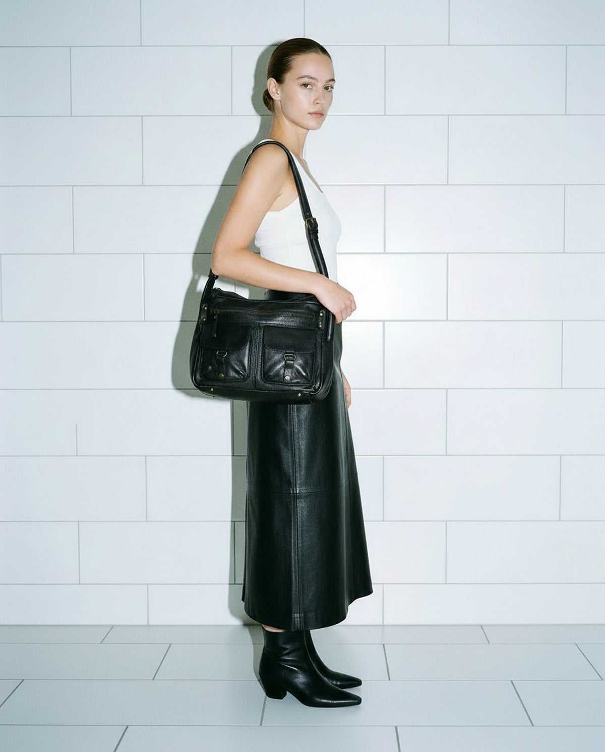 Sac Saga noir AUNE — sac bandoulière en cuir de vachette lisse porté à l'épaule — AUNE